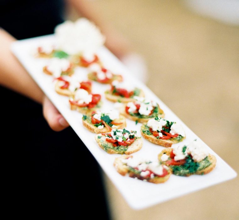 Roasted red pepper crostini served on white catering platter